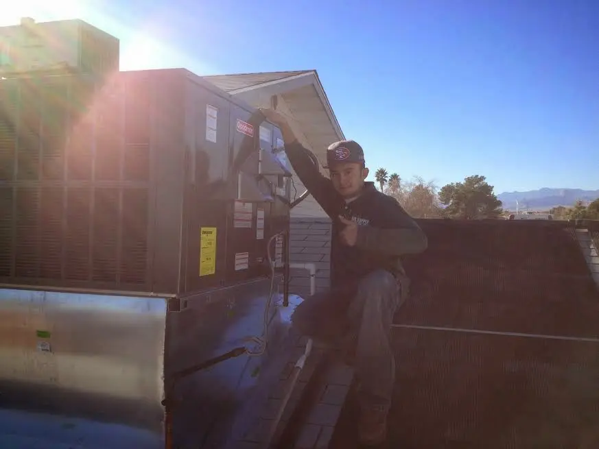 HVAC technician performing HVAC Inspection on a rooftop unit in Oregon